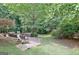 Inviting backyard featuring a brick patio with seating, lush greenery, and a serene natural setting at 102 Passage Point, Peachtree City, GA 30269
