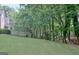 A spacious backyard with lush green grass and a wooded border offers privacy and a connection to nature at 102 Passage Point, Peachtree City, GA 30269