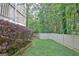 Side yard featuring a privacy fence, lush shrubs, and mature trees, offering a serene outdoor space at 102 Passage Point, Peachtree City, GA 30269
