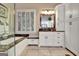 Bright bathroom featuring white cabinetry, marble countertops, and a window with natural light at 102 Passage Point, Peachtree City, GA 30269