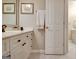 Neutral-toned bathroom featuring a white vanity with a framed mirror and tile flooring at 102 Passage Point, Peachtree City, GA 30269