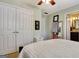 Bright bedroom featuring double closets, ceiling fan, and an ensuite bathroom at 102 Passage Point, Peachtree City, GA 30269