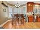 A well-lit dining area with a wood dining table, chairs, chandelier, and large window with plantation shutters at 102 Passage Point, Peachtree City, GA 30269