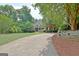 Beautiful landscaped home exterior with a long driveway lined with mature trees and lush greenery at 102 Passage Point, Peachtree City, GA 30269