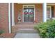 Inviting front door with decorative wreaths, potted plants and an elegant wrought iron accent piece at 102 Passage Point, Peachtree City, GA 30269