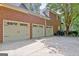 Attached three-car garage featuring carriage style doors and a spacious concrete driveway at 102 Passage Point, Peachtree City, GA 30269