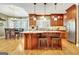 A well-lit kitchen featuring custom wood cabinets, stainless appliances, granite counters, hardwood floors, and a kitchen island at 102 Passage Point, Peachtree City, GA 30269