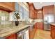 Detailed view of a kitchen showcasing granite countertops, wooden cabinets, stainless steel appliances, and hardwood flooring at 102 Passage Point, Peachtree City, GA 30269