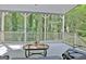 Covered porch overlooks a wooded area with seating and a table, providing a peaceful outdoor retreat at 102 Passage Point, Peachtree City, GA 30269