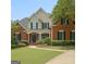 Charming brick home featuring a well-manicured lawn and inviting entrance with black shutters at 102 Passage Pt, Peachtree City, GA 30269