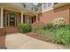 Inviting front porch with beautiful landscaping, columns, and an arched front door with floral decor at 102 Passage Pt, Peachtree City, GA 30269