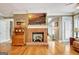 Living room showcasing a brick fireplace, hardwood floors, and bright natural light from shuttered windows at 102 Passage Pt, Peachtree City, GA 30269