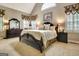 Luxurious main bedroom featuring a king bed, sitting area, and large windows with custom drapes at 102 Passage Pt, Peachtree City, GA 30269