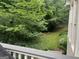 View from deck to green lawn, mature landscaping and lush trees at 102 Passage Pt, Peachtree City, GA 30269
