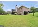 Green backyard with a brick house, deck, landscaping, and a fenced area at 186 Ashley Dr, Mcdonough, GA 30252