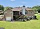 Expansive backyard featuring a brick home, a deck, and lush green lawn at 186 Ashley Dr, Mcdonough, GA 30252