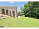 Backyard view showcasing house exterior, a wooden staircase, and a green lawn at 186 Ashley Dr, Mcdonough, GA 30252