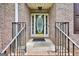 Elegant front door with decorative glass, surrounded by brick and black iron railings at 186 Ashley Dr, Mcdonough, GA 30252