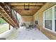 Covered patio with brick pillars and wood ceiling, stairs to back yard, and outdoor furniture at 186 Ashley Dr, Mcdonough, GA 30252