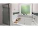 Bright bathroom featuring soaking tub with window view and marble style tiles in shower area at 30 Hollyhock Ln, Covington, GA 30014
