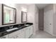 Bright bathroom with double vanity featuring black countertop and white cabinets, plus framed mirrors at 30 Hollyhock Ln, Covington, GA 30014