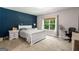 Bright bedroom with a navy accent wall, white furniture, and natural light streaming through the windows at 30 Hollyhock Ln, Covington, GA 30014