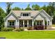 Inviting covered porch with stone accents, rocking chairs, and charming landscaping at 30 Hollyhock Ln, Covington, GA 30014