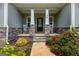 Charming front porch with stone pillars, rocking chairs, and blooming landscaping at 30 Hollyhock Ln, Covington, GA 30014