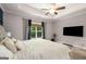Bright main bedroom featuring a tray ceiling, a ceiling fan, and a large window at 30 Hollyhock Ln, Covington, GA 30014