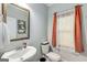 Cozy powder room with a decorative mirror and an orange curtain at 30 Hollyhock Ln, Covington, GA 30014