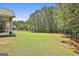 Expansive backyard with lush green grass, a black metal fence, and privacy provided by mature trees at 45 Coral Ridge Ct, Palmetto, GA 30268