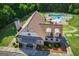 Aerial view of the community clubhouse with a pool, ample parking, and lush landscaping in a wooded setting at 45 Coral Ridge Ct, Palmetto, GA 30268