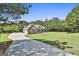 Gorgeous house with a long driveway and an expansive green front yard surrounded by lush trees at 45 Coral Ridge Ct, Palmetto, GA 30268