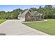 Beautiful Gathering home with lush greenery and landscaping alongside a long, concrete driveway at 45 Coral Ridge Ct, Palmetto, GA 30268