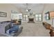Spacious living room featuring a stone fireplace, a ceiling fan, and plush gray carpeting at 45 Coral Ridge Ct, Palmetto, GA 30268