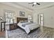 Bright bedroom with light walls, windows, hardwood-style floors, and a tray ceiling with ceiling fan at 45 Coral Ridge Ct, Palmetto, GA 30268