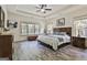 Bright main bedroom with tray ceiling, ceiling fan, hardwood floors, and natural light from large windows at 45 Coral Ridge Ct, Palmetto, GA 30268