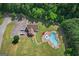 Aerial view of a community pool with plenty of seating, lush greenery, and a clubhouse nearby at 45 Coral Ridge Ct, Palmetto, GA 30268