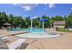 Community pool featuring a zero-entry splash area, lounge chairs, and mature trees, ideal for Gathering fun at 45 Coral Ridge Ct, Palmetto, GA 30268