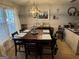 Inviting dining room with a large dark wood table set for six under a modern chandelier at 435 Rosehill Dr, Mcdonough, GA 30253