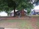 Charming single-story home with brick chimney and a cozy front porch swing, shaded by a large tree at 435 Rosehill Dr, Mcdonough, GA 30253