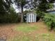 Backyard shed with double doors surrounded by mature trees and a neatly mowed lawn at 435 Rosehill Dr, Mcdonough, GA 30253