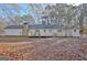 Backyard view of home showing deck, stone chimney, and leaf-covered lawn at 435 Crabapple Rd, Fayetteville, GA 30215