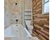 Modern bathroom with a soaking tub, tiled walls, planked wood accents and a glass shower door at 435 Crabapple Rd, Fayetteville, GA 30215