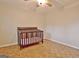 Bedroom with parquet flooring and crib under ceiling fan at 435 Crabapple Rd, Fayetteville, GA 30215