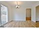 Bright dining area with wood floors, slider access to deck, and stylish chandelier fixture at 435 Crabapple Rd, Fayetteville, GA 30215