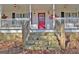Inviting front porch with stone steps, a red door, and charming decorative touches at 435 Crabapple Rd, Fayetteville, GA 30215