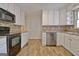 Classic kitchen featuring white cabinets, stainless steel appliances, and a mosaic tile backsplash at 435 Crabapple Rd, Fayetteville, GA 30215