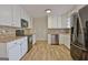 Well-lit kitchen with white cabinets, stainless steel appliances, and tiled backsplash at 435 Crabapple Rd, Fayetteville, GA 30215