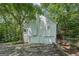 Home exterior showcasing a two-car garage and deck among a lush backdrop of trees at 230 Vienna Way, Douglasville, GA 30134